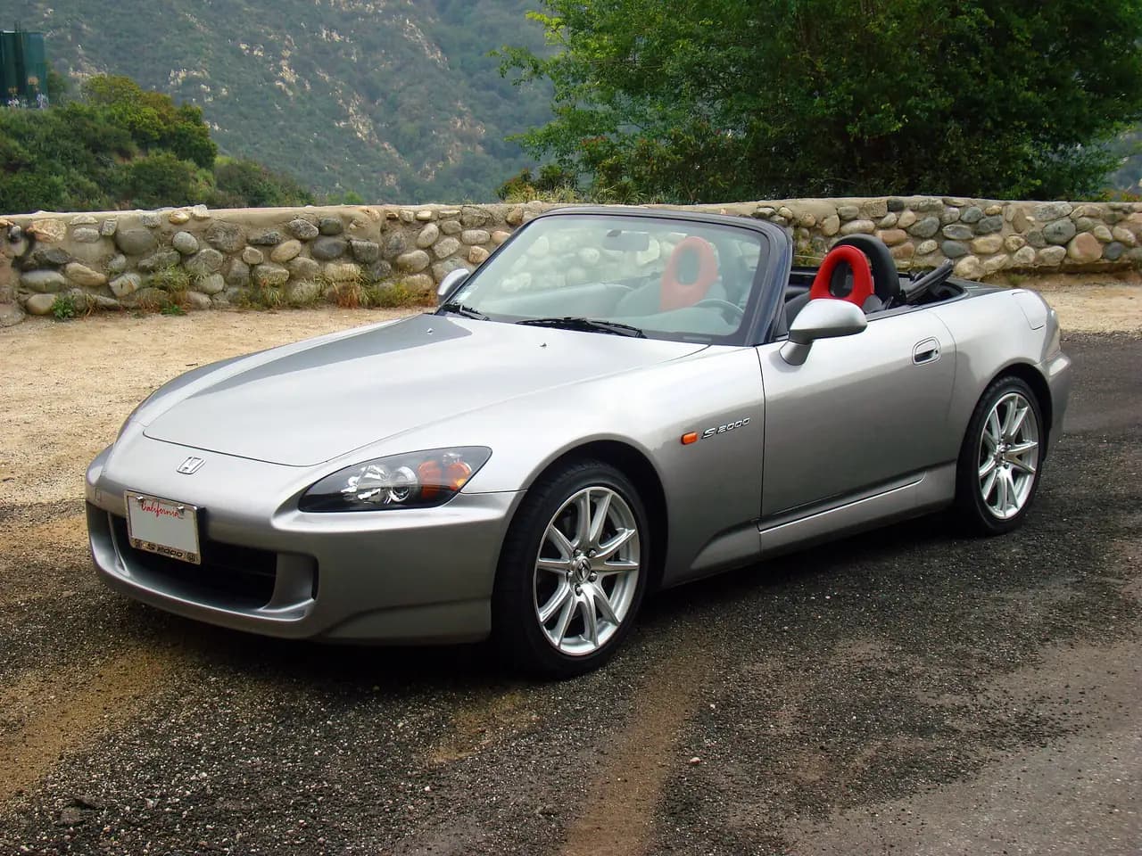 Silver 2005 Honda S2000 (AP2) roadster, roof down, front three-quarter view