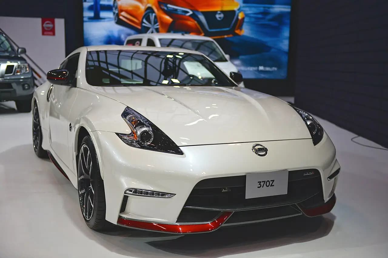 White 2020 Nissan 370Z Nismo coupe (Z34) on an auto show stand, front three-quarter view