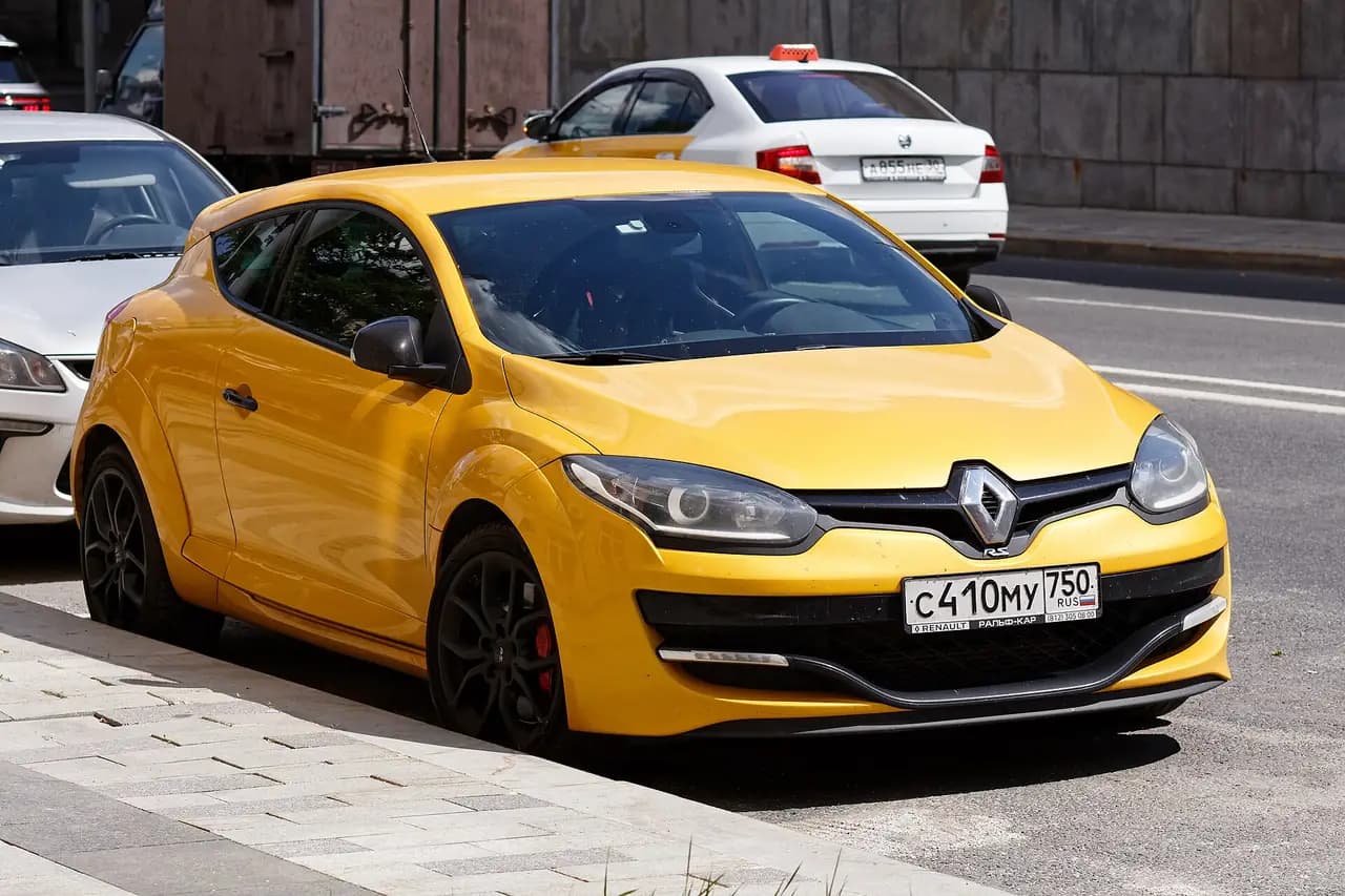 Yellow Renault Megane R.S. (Mk3, 2014-16 facelift) coupe, front three-quarter view