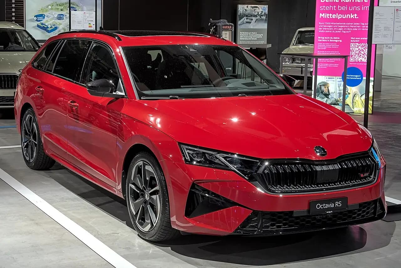 Red Skoda Octavia RS wagon (NX facelift) on a motor show floor, front three-quarter view