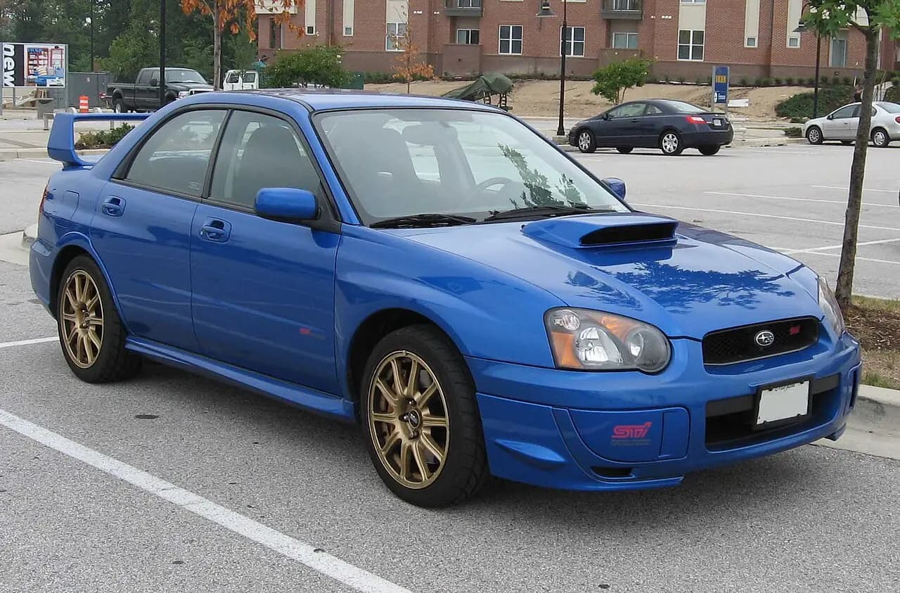 WR Blue 2004-05 Subaru Impreza WRX STI (GD blobeye) sedan, gold wheels, front three-quarter view