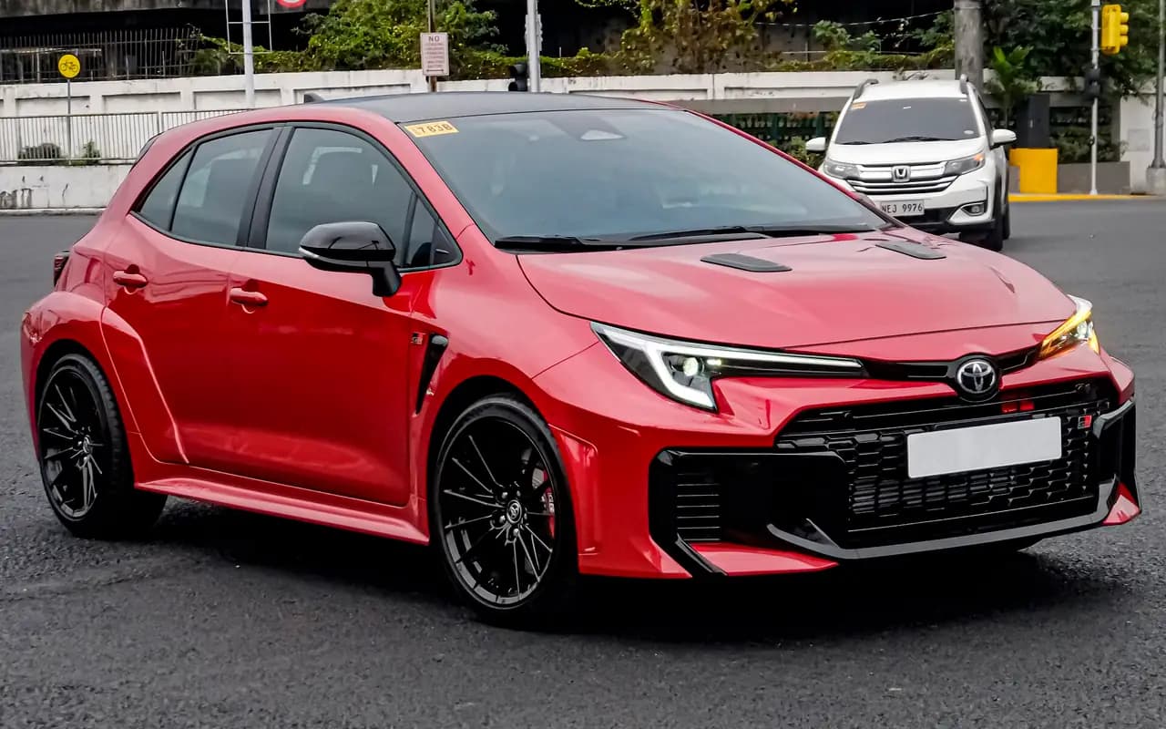 Red facelifted Toyota GR Corolla (GZEA14) hatch, front three-quarter view
