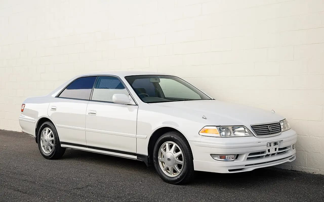 White Toyota Mark II 2.5 Grande G (JZX100) hardtop, front three-quarter view