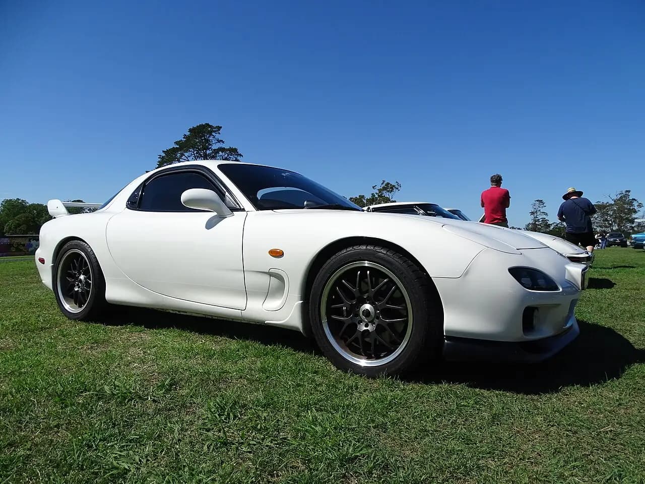 White Efini RX-7 (FD3S Series 7) with high rear wing, low front three-quarter view on grass