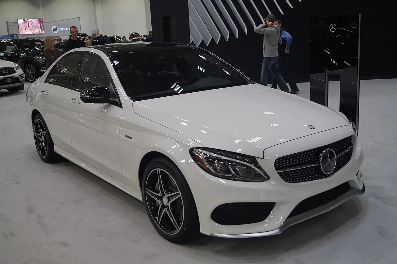White pre-facelift Mercedes-AMG C 43 sedan (W205) at a motor show, front three-quarter view