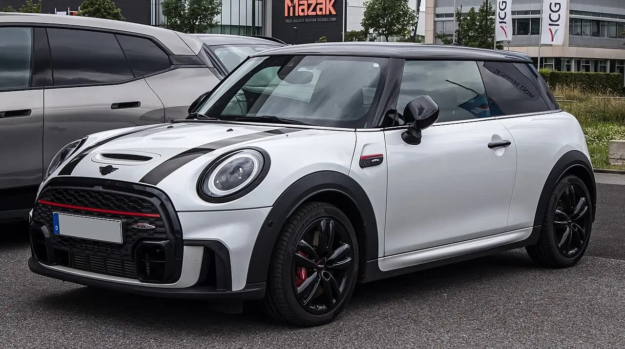 White Mini John Cooper Works 3-door hatch (F56 LCI2) with black bonnet stripes, front three-quarter view