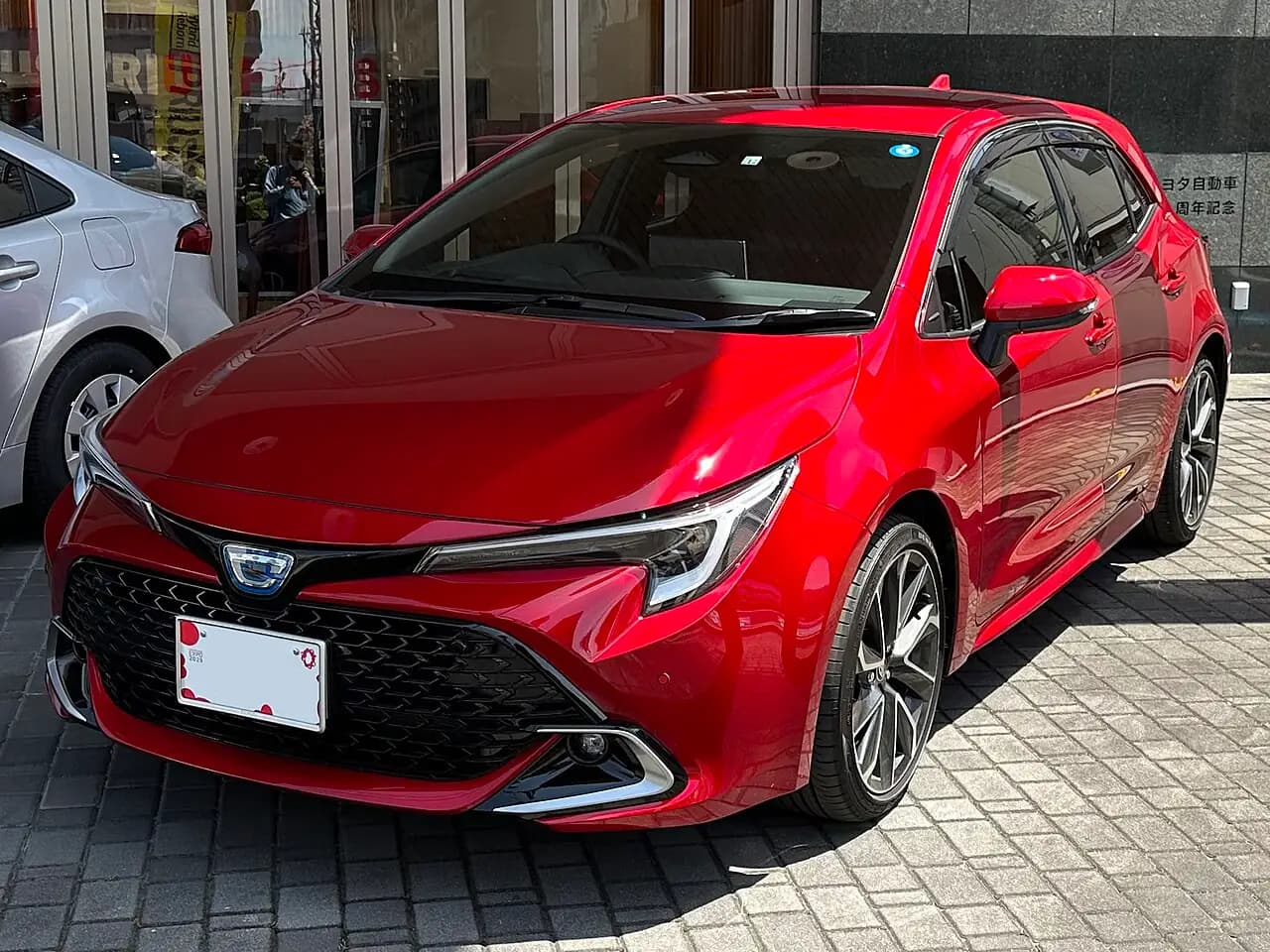 Red Toyota Corolla Sport Hybrid G"Z" hatchback (E210 facelift), front three-quarter view